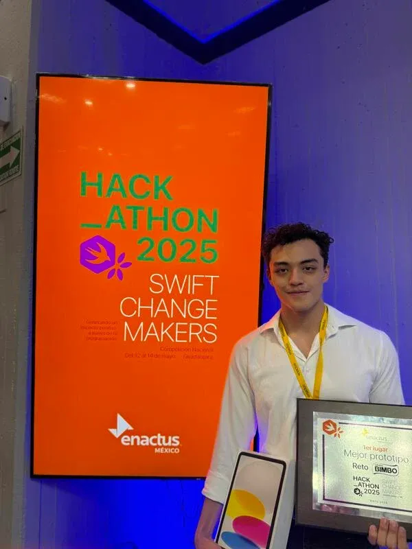Luis with the Best Prototype award beside the Swift Change Makers 2025 event display